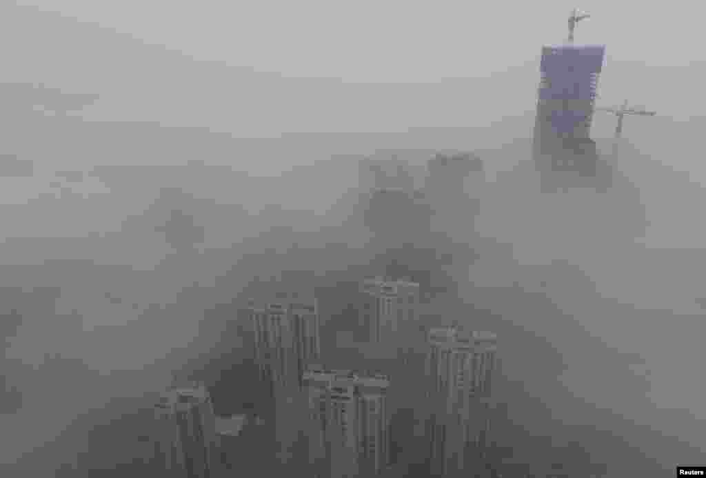 Buildings are seen shrouded in heavy haze at Qingdao development zone, Shandong province, Feb. 25, 2014. 