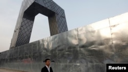 Seorang pria berjalan di luar bangunan stasiun Televisi Pemerintah China (CCTV), Beijing (Foto: dok).