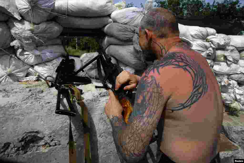 Seorang militan pro-Rusia di posisi pertahanan terdepan dengan senjata mesin di kota Slovyansk (19/5).&nbsp;(Reuters/Yannis Behrakis)
