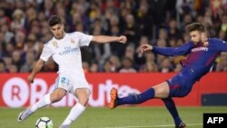 Marco Asensio, le milieu de terrain du Real Madrid, rivalise avec le défenseur espagnol de Barcelone, Gerard Pique au stade Camp Nou de Barcelone, le 6 mai 2018.