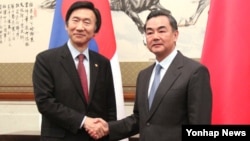 윤병세 한국 외교장관과 왕이 중국 외교부장이 24일 베이징 댜오위타이 국빈관에서 한중 외교장관 회담에 앞서 악수를 나누고 있다.