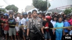 Polisi berjaga di sekitar lokasi serangan bom di gereja GBIS Solo, sementara masyarakat setempat ikut menonton (25/9). Aksi teror di Indonesia dikhawatirkan menjadi ideologi perlawanan anti kemapanan.