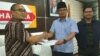 Juru bicara Forluni UNJ Ide Bagus Arif berpeci hitam menyerahkan data terkait kasus plagiarisme di UNJ kepada anggota komisi X DPR RI Dadang Rusdiana. (Foto dokumentasi: Forluni UNJ).