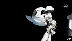 In this photo provided by NASA, the SpaceX Crew Dragon is pictured about 20 meters (66 feet) away from the International Space Station’s Harmony module, March 3, 2019. It left Friday to splash down in the Atlantic.