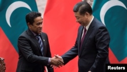 Maldives President Abdulla Yameen shakes the hand of China's President Xi Jinping after a signing meeting at the Great Hall of the People in Beijing, China, Dec. 7, 2017. 