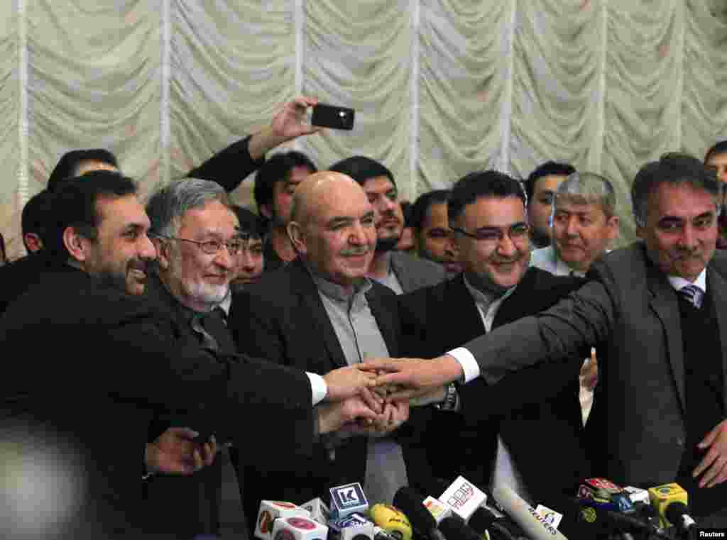 Presidential candidate Zalmai Rassoul (2nd L) shakes hands with Qayum Karzai (C) and their teams in Kabul, March 6, 2014. Karzai has announced he is withdrawing from the presidential race.