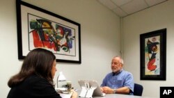 FILE - Kim Mueller, left, administers a test to Alan Sweet, in which he describes an illustration, as part of a University of Wisconsin-Madison study on dementia, July 6, 2017. 