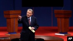 This Oct. 3, 2012 file photo shows moderator Jim Lehrer addressing the audience before the first presidential debate at the University of Denver in Denver. 