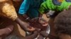 FILE - In this May 1, 2012 photo, Maryam Sy and five of her nine children share a meager bowl of tamarind-flavored porridge, some of the only food they will get that day, in the village of Goudoude Diobe, in Matam region of Senegal.