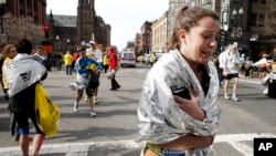Seorang peserta lomba lari marathon Boston menangis di dekat Copley Square setelah terjadinya ledakan (15/4). 