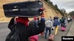 Venezuelan migrants walk along the Ecuadorean highway to Peru before new rules requiring they hold a valid passport kick in, at Tulcan, Ecuador, Aug. 21, 2018. 