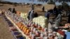 FILE - This handout photo provided by World Relief shows emergency food being distributed by World Food Program and World Relief in Kulbus, West Darfur, Sudan, in March 2024. (World Relief via AP)