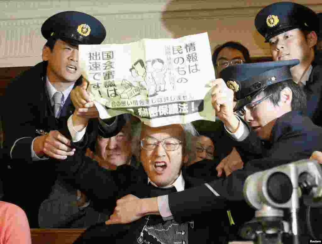 Seorang demonstran melakukan protes pada saat rapat komisi Majelis Rendah parlemen Jepang di Tokyo, untuk membahas usul PM Shinzo Abe untuk memperluas UU Kerahasiaan Negara.