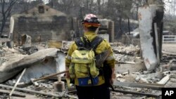 Seorang petugas pemadam kebakaran memeriksa kawasan yang terbakar dalam kebakaran lahan di Keswick, California, 29 Juli 2018.