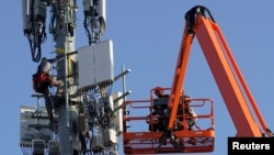 FILE - A Verizon contract crew installs 5G telecommunications equipment on a tower in Orem, Utah, Dec. 3, 2019.
