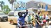 Supporters of opposition leader Kizza Besigye flash the peace sign, or victory sign, to show solidarity with their candidate in the suburb of Ntinda, Uganda, Feb. 16, 2016. (Photo: Lizabeth Paulat for VOA) 