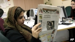 Wartawan Iran Elahe Khosravi, membaca harian Iran "Hamshahri" di Teheran, Iran (Foto: dok). Iran mengadakan lomba menggambar karikatur Holocaust atau pembantaian Yahudi di Eropa tahun 1940-an untuk yang ke-3 kalinya akhir pekan ini.