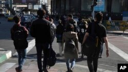Sekelompok perempuan muda Iran menyeberangi jalan tanpa menggunakan hijab yang menjadi kewajiban di Teheran, Iran, Senin, 4 November 2022. (Foto: Vahid Salemi/AP Photo)