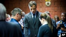 Oscar Pistorius (tengah) berdoa bersama saudara perempuannya Aimee dan saudara lelakinya Carl sebelum sidang dakwaannya dimulai di Pretoria (19/8).