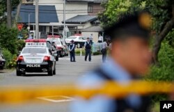 Police officers stand guard at a crossroad near the Tsukui Yamayuri-en, a facility for the handicapped, where a number of people were killed and dozens injured in a knife attack in Sagamihara, outside of Tokyo, Japan, July 26, 2016.