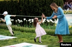 U.S. first lady Melania Trump high fives a child at the hopscotch station during the 2019 White House Easter Egg Roll on the South Lawn of the White House in Washington, April 22, 2019.