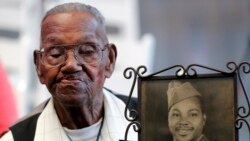 FILE - World War II veteran Lawrence Brooks holds a photo of him taken in 1943, as he celebrates his 110th birthday at the National World War II Museum in New Orleans, on Sept. 12, 2019.