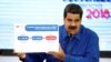 Venezuela's President Nicolas Maduro holds a banner explaining the new minimum wage as he speaks during a news conference in Caracas, Venezuela, April 30, 2018. 