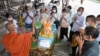 ប្រជាពលរដ្ឋកម្ពុជាប្រគេនម្ហូបនិងបច្ច័យដល់ព្រះសង្ឃ នៅវត្តមួយក្នុងខេត្តព្រៃវែង នារដូវបុណ្យភ្ជុំ កាលពីថ្ងៃទី ៥ ខែតុលា ឆ្នាំ២០២១។ 