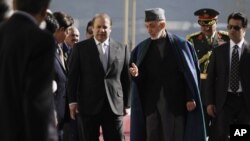Afghan President Hamid Karzai, center right, talks with Pakistan Prime Minister Nawaz Sharif while they inspect honor guard, Kabul, Nov. 30, 2013.