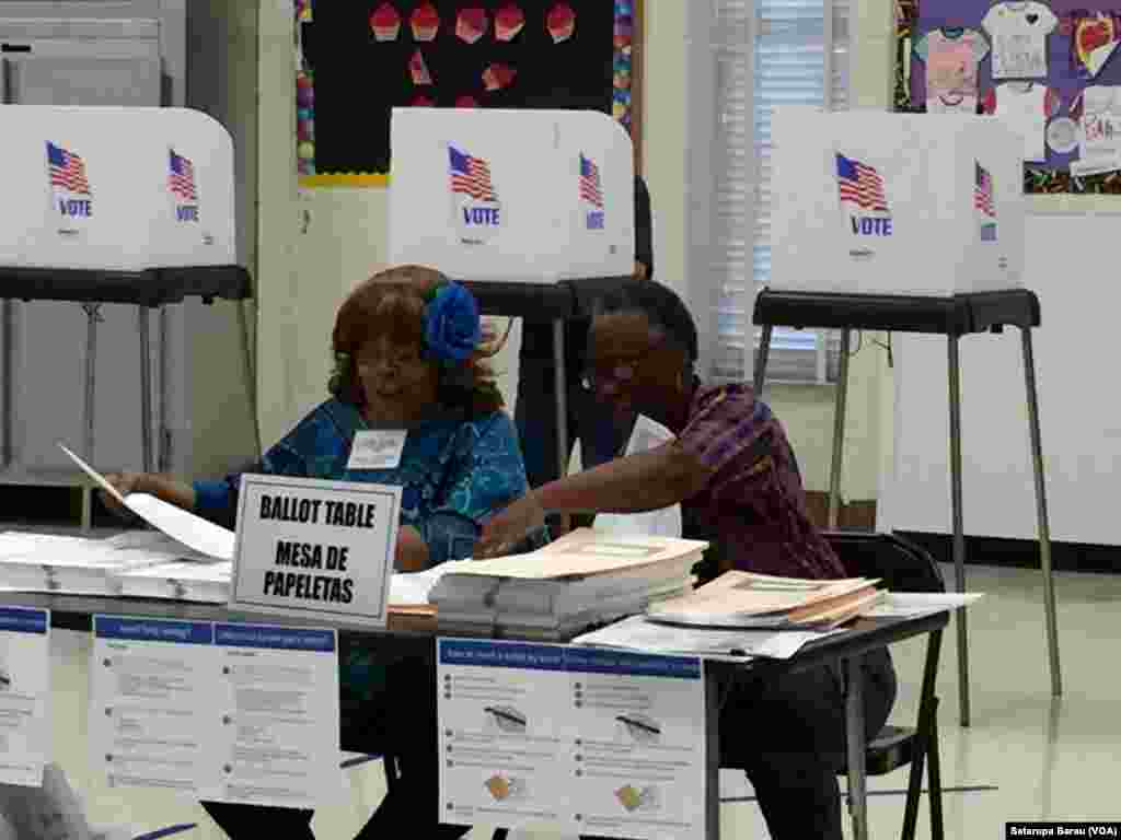 Precinct volunteers look over paperwork at a polling station at Watkins Mill Elementary School in Montgomery Village, Maryland, April 26, 2016.