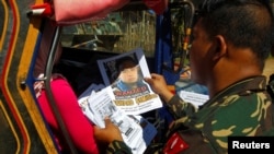 Para tentara membagikan gambar Isnilon Hapilon, anggota kelompok ekstremis Abu Sayyaf. Pemerintah AS menjanjikan hadiah 5 juta dolar untuk penangkapan Isnilon di Butig, Lanao del Sur di selatan Filipina, 1 Februari, 2017. 