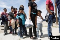 FILE - Central American migrants stand in line before entering a temporary shelter, after illegally crossing the border between Mexico and the U.S., in Deming, New Mexico, May 16, 2019.