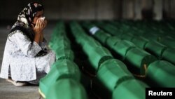 A Bosnian Muslim cries near the coffin of her relative, which was prepared for a mass burial at the Memorial Center in Potocari, near Srebrenica, July 10, 2012.