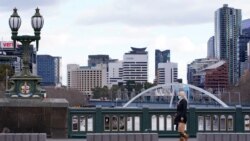 A lone woman, wearing a protective face mask, walks across an unusually quiet city centre bridge on the first day of a lockdown as the state of Victoria looks to curb the spread of a coronavirus disease (COVID-19) outbreak in Melbourne, Australia, July 16