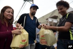 Actor and composer of Puerto Rican descent Lin Manuel Miranda distributes food to victims of Hurricane Maria in 'La Placita de Güisin', in Vega Alta, Puerto Rico, Nov. 7, 2017.