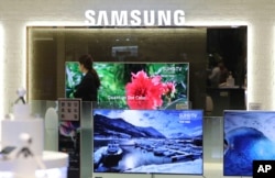A shopper walks by a Samsung Electronics store in Seoul, South Korea, April 7, 2017. Samsung Electronics said in early April that its first-quarter profit jumped 48 percent.
