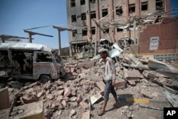 FILE - A man inspects rubble after a Saudi-led coalition airstrike in Sana'a, Yemen, Feb. 4, 2018.