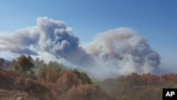 This photo provided by California Department of Forestry and Fire Protection shows smoke billowing from a wildfire near Lake Nacimiento in San Luis Obispo County, Calif., Aug. 20, 2016. 