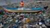 FILE - A fisherman prepares his net on the shores of the Arabian Sea, littered with plastic bags, in Mumbai, India, Oct. 1, 2015. At the Our Ocean summit that concluded Friday, five countries detailed plastic bag bans.