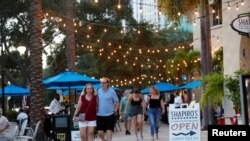 Sejumlah pengunjung berjalan-jalan tanpa masker di pusat Kota St. Petersburg, Florida, di tengah pandemi virus corona, 6 Agustus 2021. 