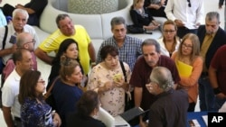 FILE - People inquire about temporary positions available for the 2020 Census during a job fair designed for people fifty years or older in Miami, Sept. 18, 2019. On Friday, Dec. 6, the U.S. government issues the November jobs report. 