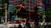 People walk by an electronic board displaying a stock trading index at a brokerage house in Beijing, China, May 24, 2017. 