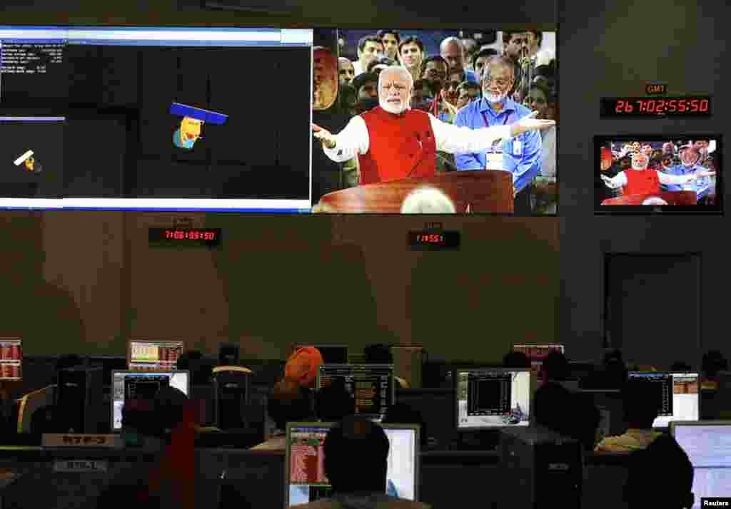 Indian Space Research Organization scientists and engineers watch Prime Minister Narendra Modi on screens after India's satellite successfully entered Mars' orbit, at the Spacecraft Control Center, in the southern Indian city of Bangalore, Sept. 24, 2014.