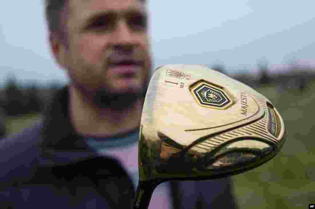 A man holds one of Viktor Yanukovych's golf clubs at the golf course on Yanukovych's countryside residence in Mezhyhirya, Feb, 22, 2014.