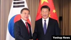 문재인 한국 대통령과 시진핑 중국 국가주석이 지난 7월 독일 베를린에서 열린 정상회담에서 악수하고 있다.