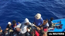 Migrants in a dinghy are rescued by the Libyan coast guard in the Mediterranean Sea off the coast of Libya, Oct. 18, 2019.