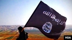 Salah seorang anggota ISIS dan benderanya (Foto: dok). Departemen Kehakiman AS, Jumat (3/4), menyatakan telah menangkap Keonna Thomas (30 tahun), yang juga dikenal sebagai Fatayat Al Khilafah atau Young Lioness, atas upayanya pergi ke luar negeri untuk bergabung dan berjuang dengan kelompok ISIS.