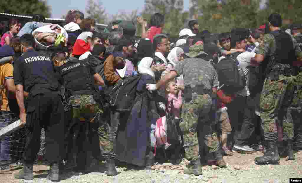 Sojoji da 'yan sandan kasar Macediniya na kokarin ganin ana bin ka'ida yayinda bakin haure ke shiga jirgin kasa kusa da birnin Gevgeliji. 