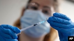 Seorang perawat menyiapkan suntikan vaksin COVID-19 buatan Pfizer-BioNTech di sebuah rumah sakit di London, Inggris, 6 Desember 2020.
