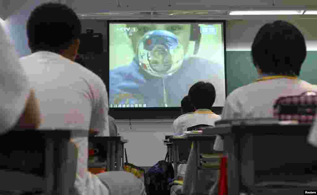 Para pelajar di sebuah sekolah di Beijing menonton siaran langsung pelajaran dari para astronot di stasiun antariksa Tiangong-1 (20/6).
